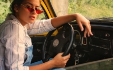 A young woman sitting behind the wheel of a car